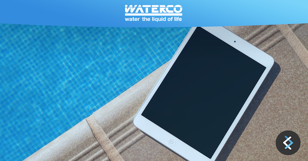 A tablet next to a pool, Waterco logo is above with DNX logo in the bottom right corner.